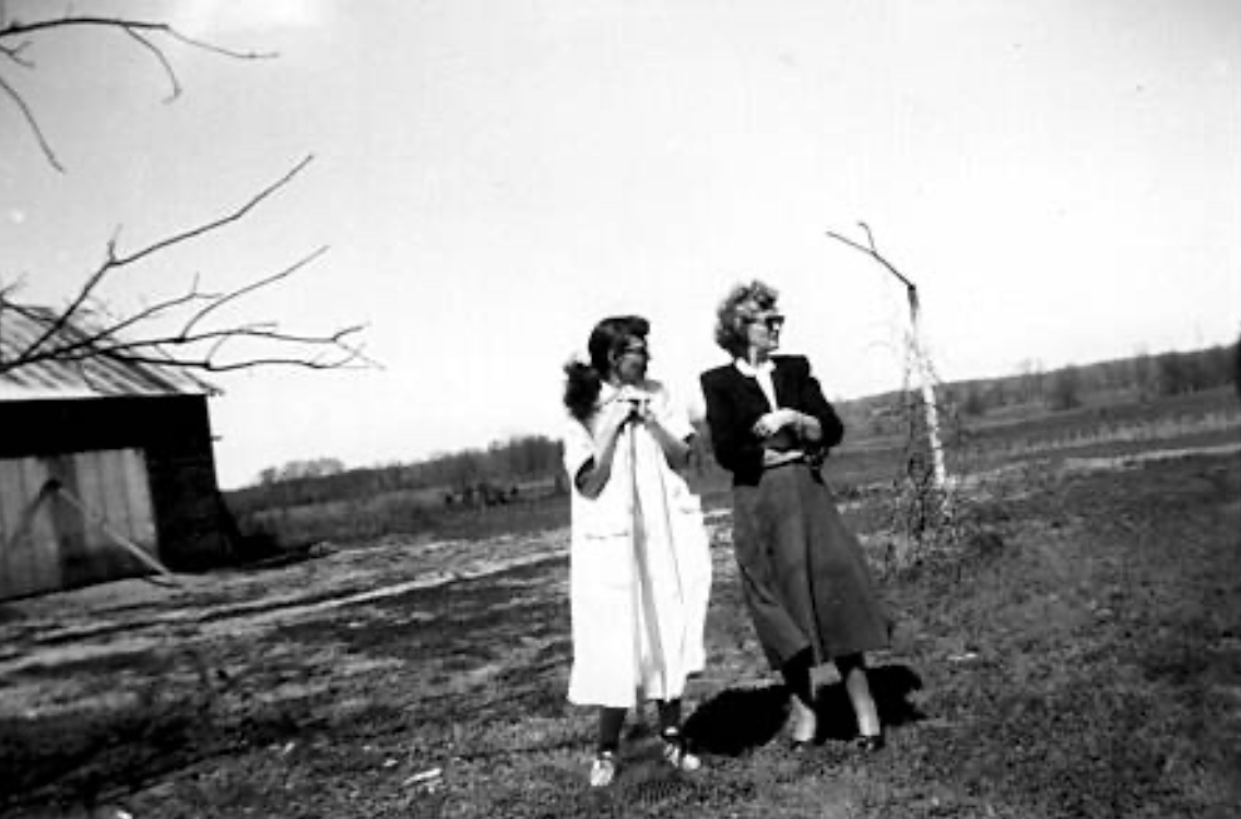 Two women standing outside in a field