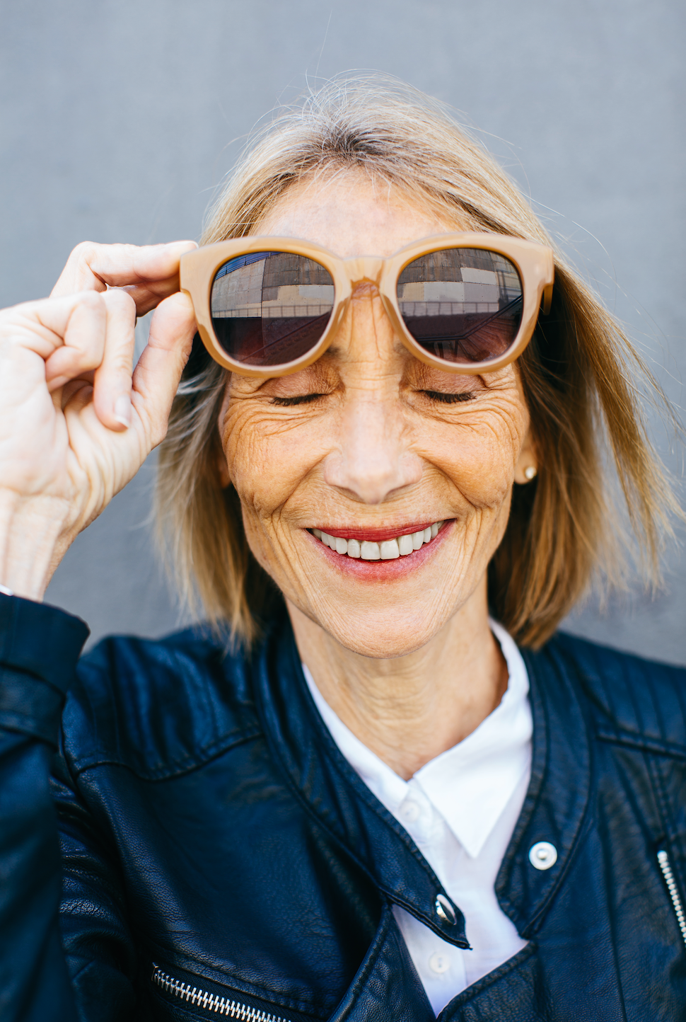 Close up face of smiling woman holding sunglasses